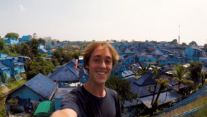 Thumbnail for vlog - Yentl Doggen in Malang in front of blue houses 