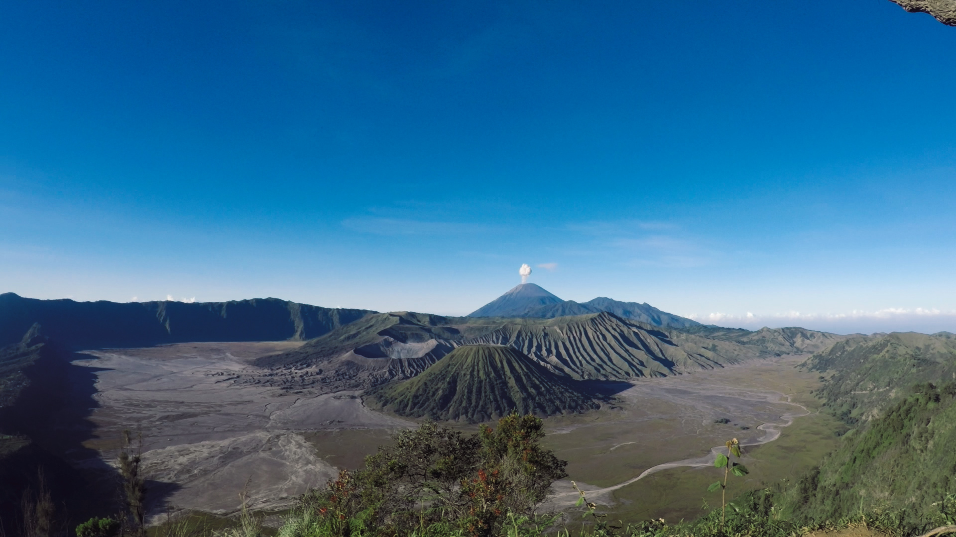 Sunrise, sandstorm and walking edges of active volcano Mt. Bromo