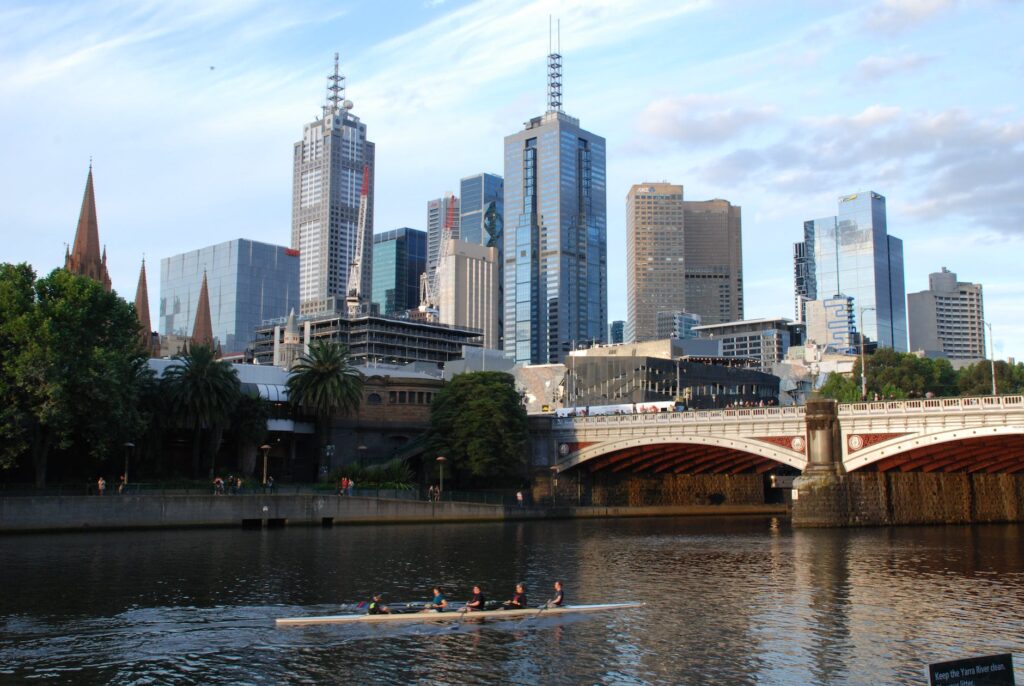 concrete bridge over river near city buildings